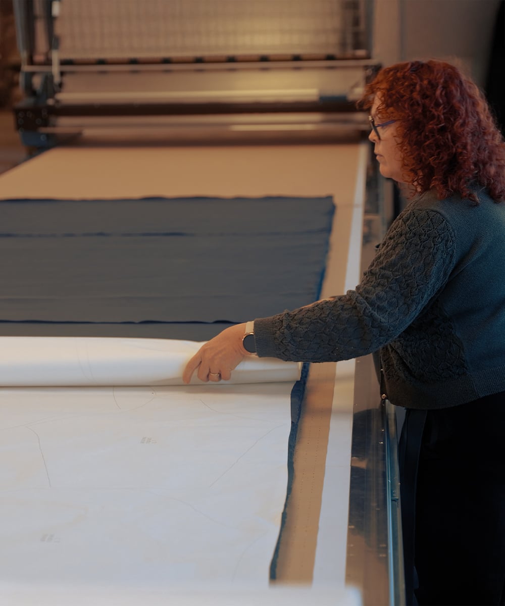 Un artisan d&eacute;coupe un tissu en coton bio
